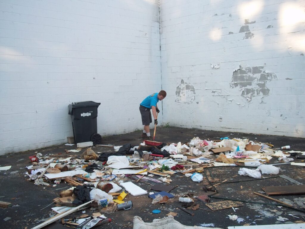 Junk Removal Atlanta Trash and debris being swept up by Stand Up Guys Junk Removal services.
